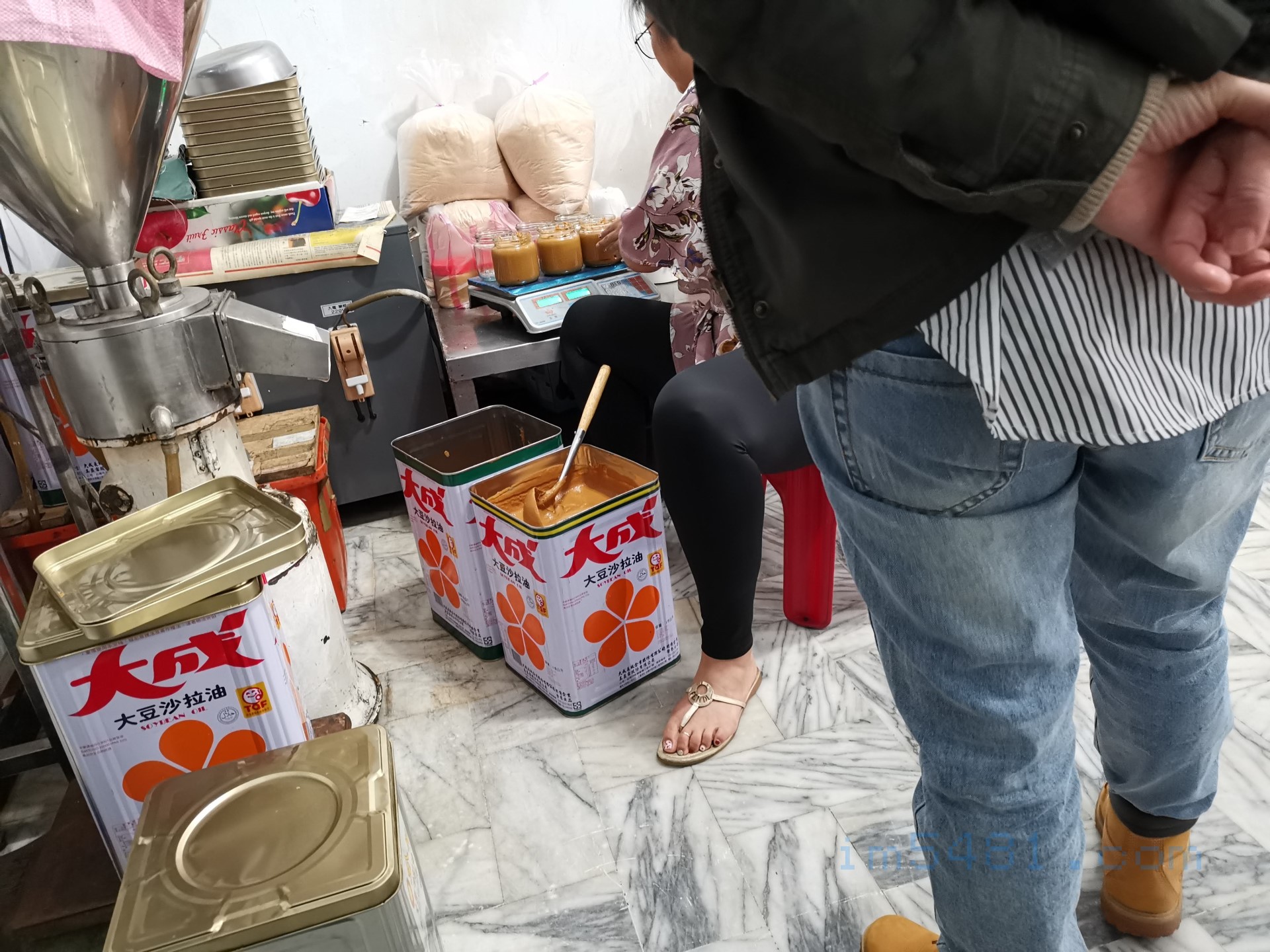老闆女兒正幫忙裝客人的花生醬跟秤重