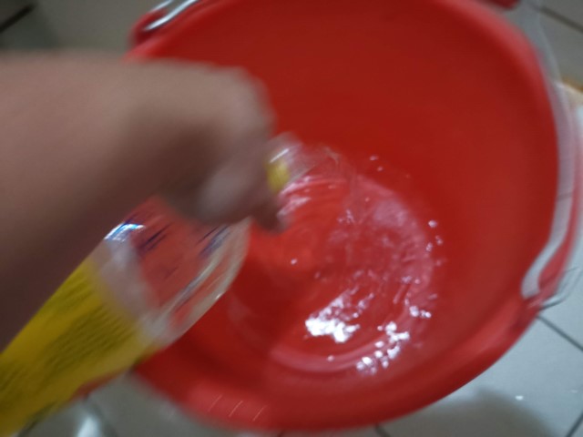 將準備稀釋的水倒進桶裡。建議醋酸水溶液濃度在浸泡衣服階段，最好約有酸度1%的醋酸濃度。